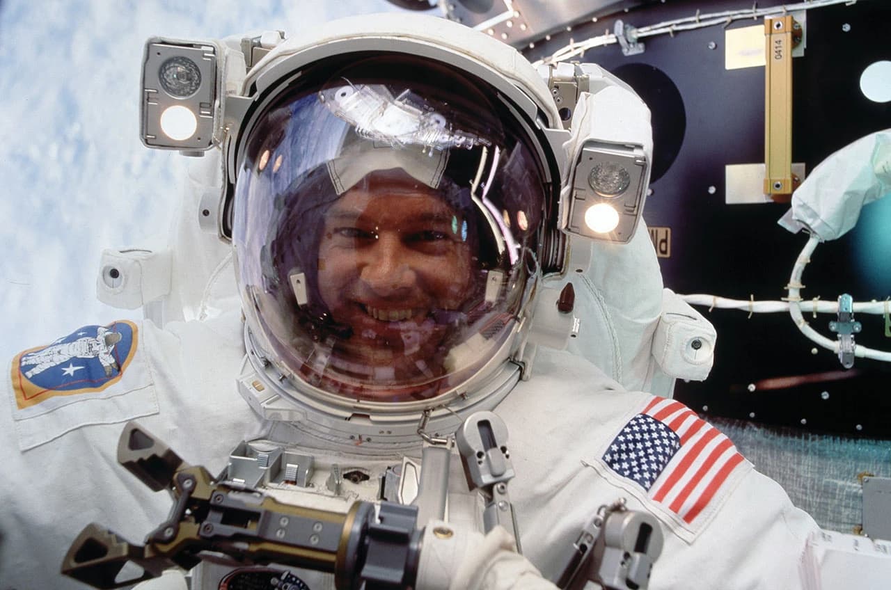 Astronaut Jeffrey Williams smiling inside his helmet on a spacewalk